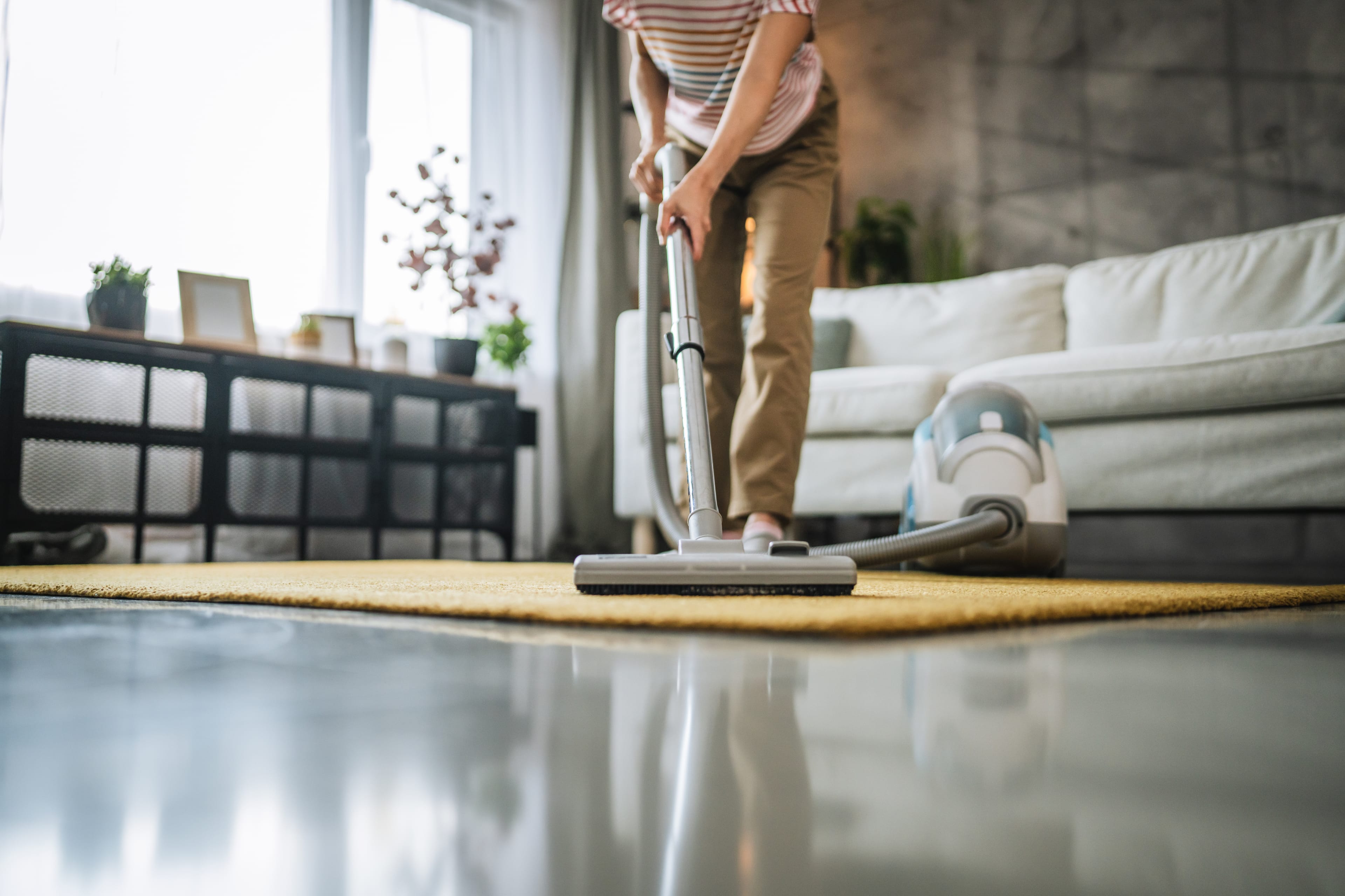 Professional cleaner vacuuming a modern living room